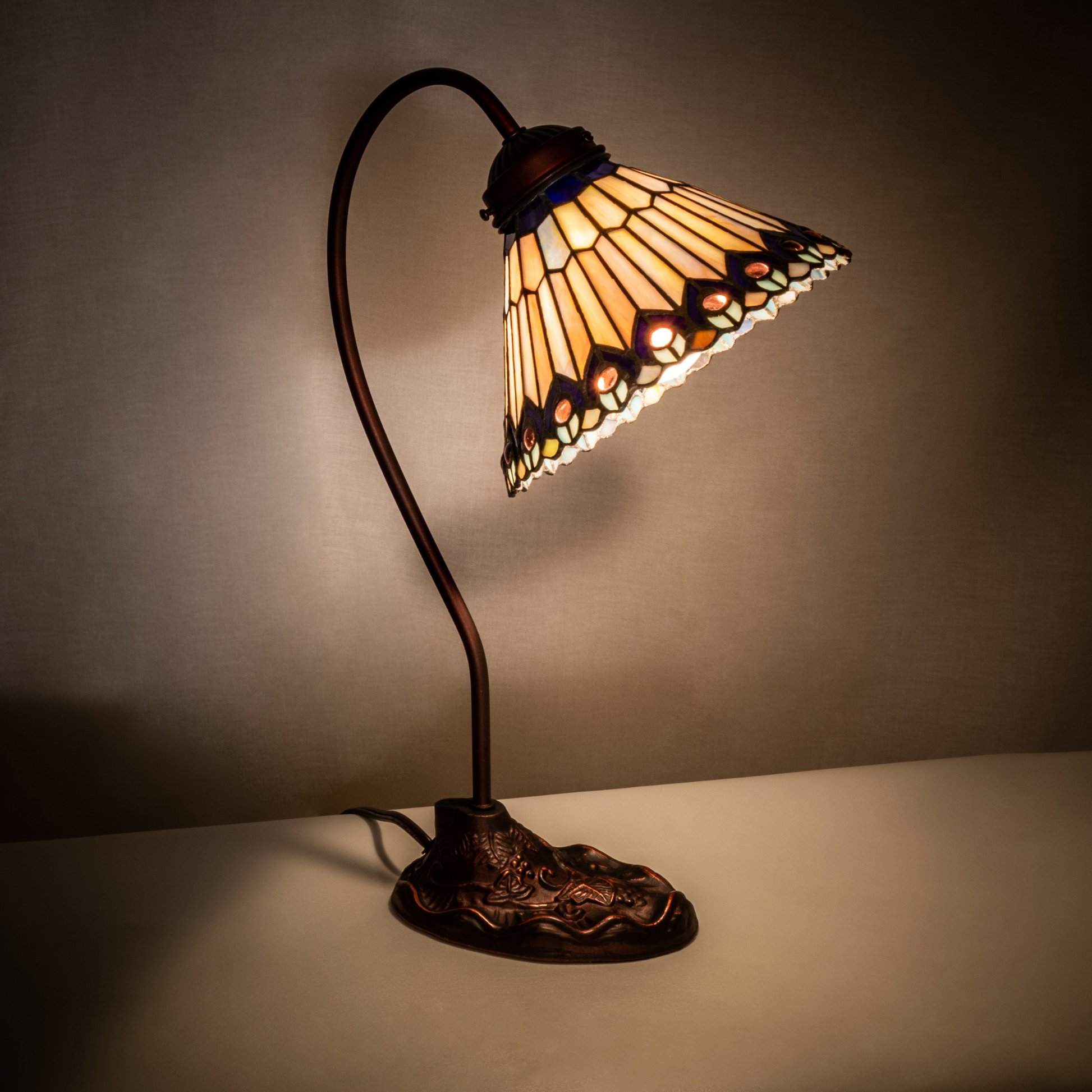 18-inch tiffany desk lamp peacock jeweled on dark background. 